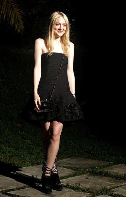 達柯塔芬妮穿著一身的香奈兒出席2014早春發表活動。黑色平口洋裝蓬蓬的裙擺上有立體的花朵造型，鍊帶鞋搭配透明小方包展現前衛個性風。圖／路透