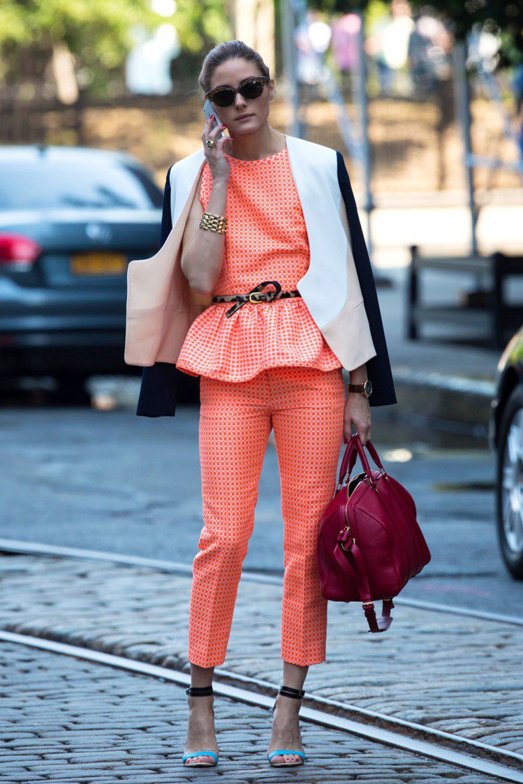 奧莉薇亞巴勒莫穿義大利設計師品牌 MSGM 的橘色背心套裝亮麗復古，搭配黑藍配的繫帶高跟涼鞋玩低調的撞色遊戲，豹紋腰帶也別具巧思。圖／達志影像