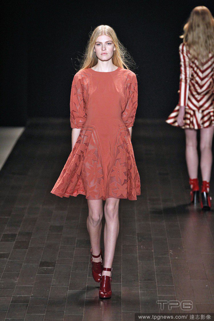 橘紅色的 Jill Stuart 洋裝看起來可愛又迷人，鏤空雕花設計增添裙襬的浪漫氣息，如果怕冷的話只要加上糖果色調的厚褲襪，就能玩出撞色美感。圖／達志影像