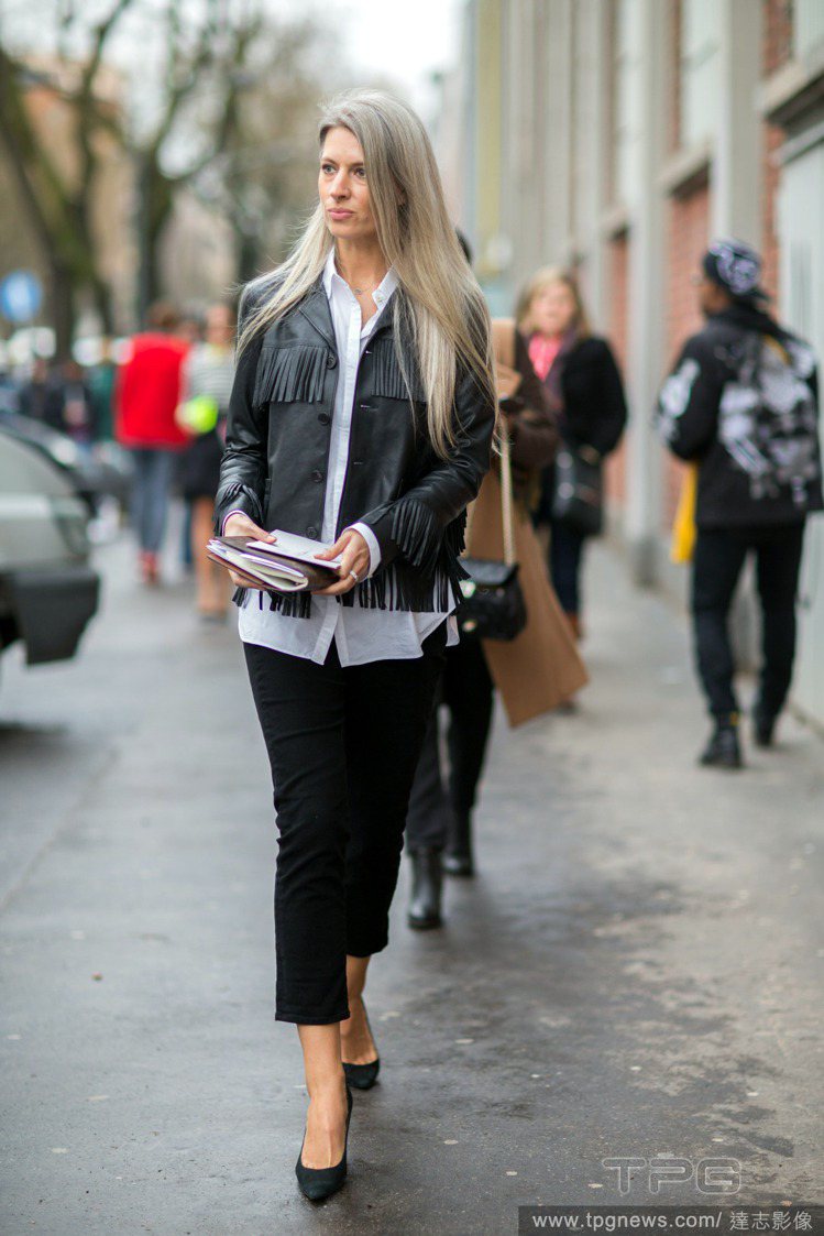 VOGUE 時尚專輯總監 Sarah Harris 穿上黑色流蘇皮革外套現身米蘭時裝周，簡簡單單就為一身 OL 造型增添變化。圖／達志影像