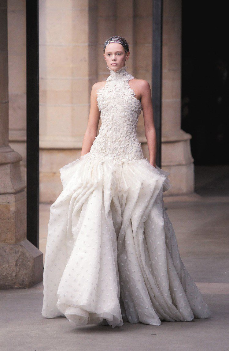 Alexander McQueen秀末的白色禮服，利用雪紡與蕾絲繁複層疊出華麗感...