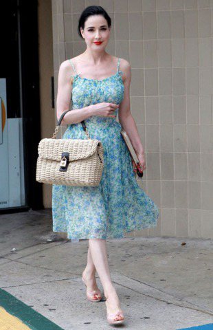 黛塔范提思拎Dolce & Gabbana藤編包上街，搭配水藍色碎花洋裝裙長及膝，很有五○年代風格。圖／達志影像