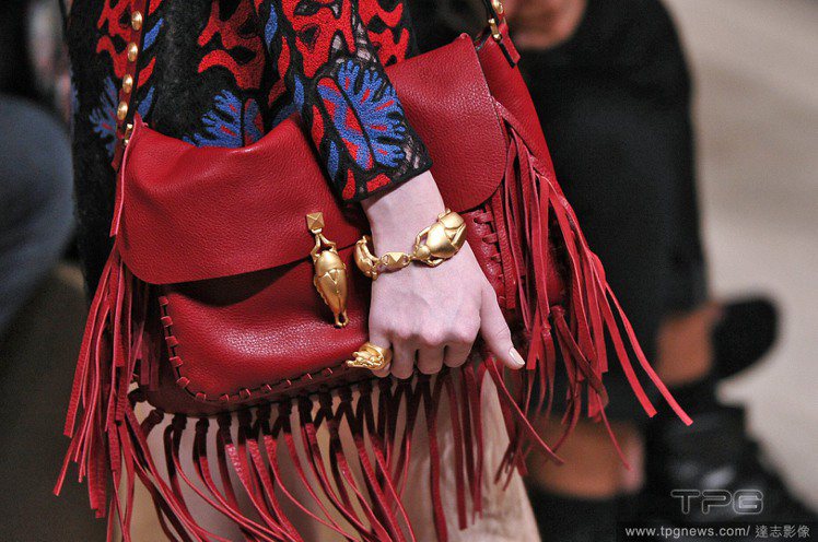 Valentino 包款有了奢華金屬細節的點綴，讓紅色流蘇更顯浪漫奢華。圖／達志影像