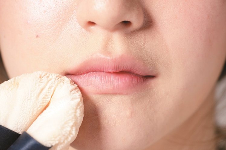 STEP1：用粉撲沾取蜜粉刷在唇上，就可以消去光澤創造霧面感。圖／美人誌提供
