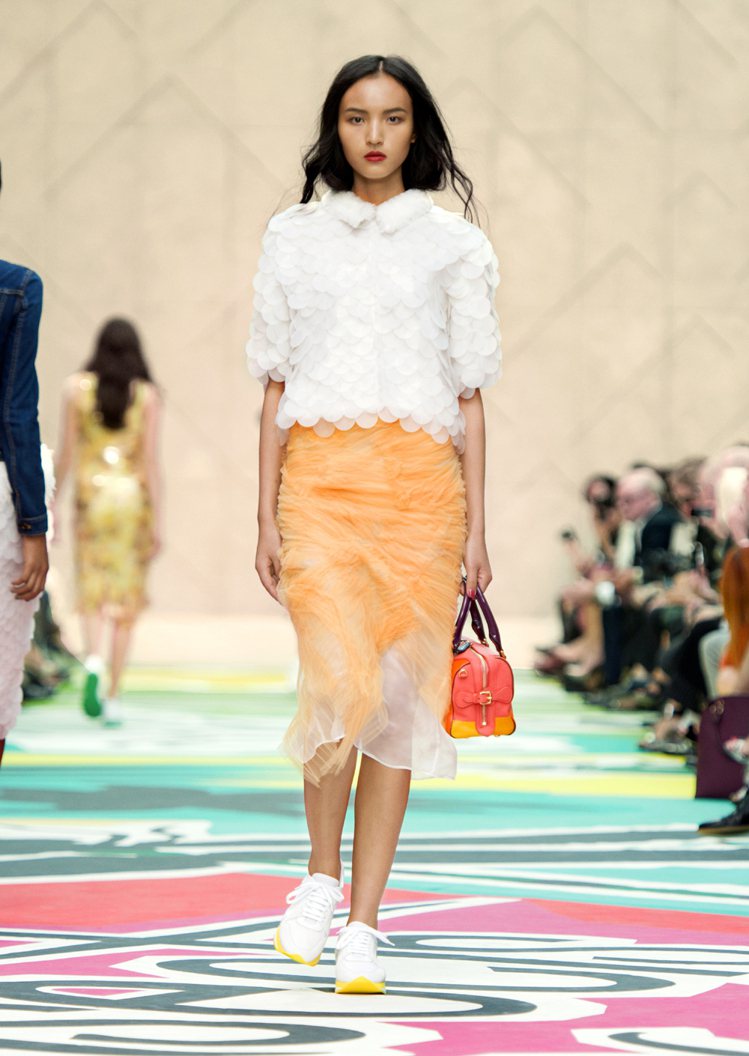 Burberry 以造型襯衫、粉橘色窄裙和白色運動鞋做搭配，看起來就像一枝漸層冰棒，清甜又消暑。圖／BURBERRY提供