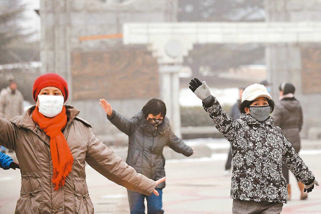 大陸空汙嚴重，影響民眾身體健康。圖為民眾戴著口罩在霧霾中晨運。