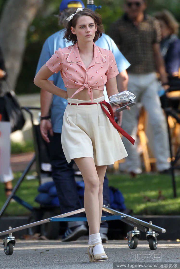 克莉絲汀史都華身穿粉紅短襯衫、白色寬版褲，還戴上蝴蝶結髮帶，非常俏麗可愛。圖／達...