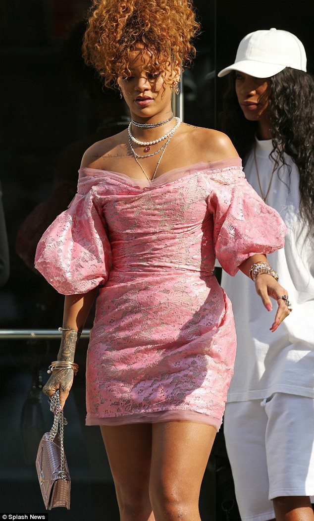 蕾哈娜一襲粉紅印花連身裙，露肩與蓬蓬袖設計，讓這件緊身裙的線條更有趣。圖／擷自每日郵報