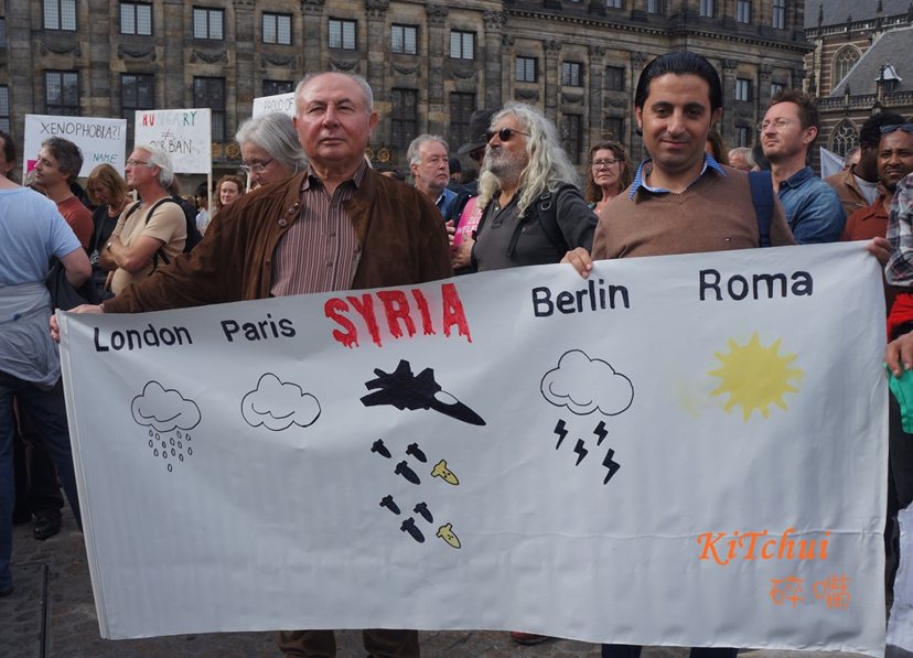 聲援敘利亞民難民的標語：敘利亞今天天氣：下炸彈。
