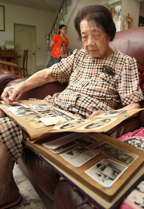 百歲人瑞黃王勝玉翻閱著超過五十年歷史的老相本。 記者林澔一／攝影