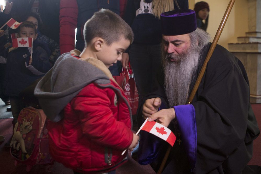 敘利亞男童受到多倫多一間亞美尼亞教堂神職人員的歡迎。圖／美聯社