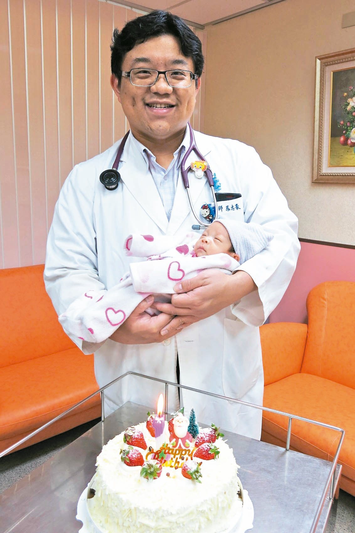 豐原醫院兒科主任馬志豪開心抱著早產男嬰，慶祝他健康出院。
