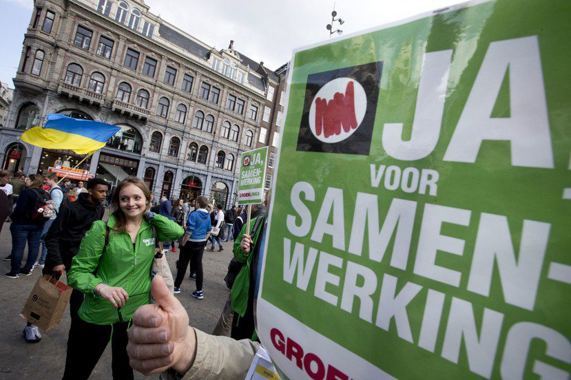 贊成陣營的民眾周日在阿姆斯特丹的路上，手持「Yes」看板。投票最終結果就等今晚了...