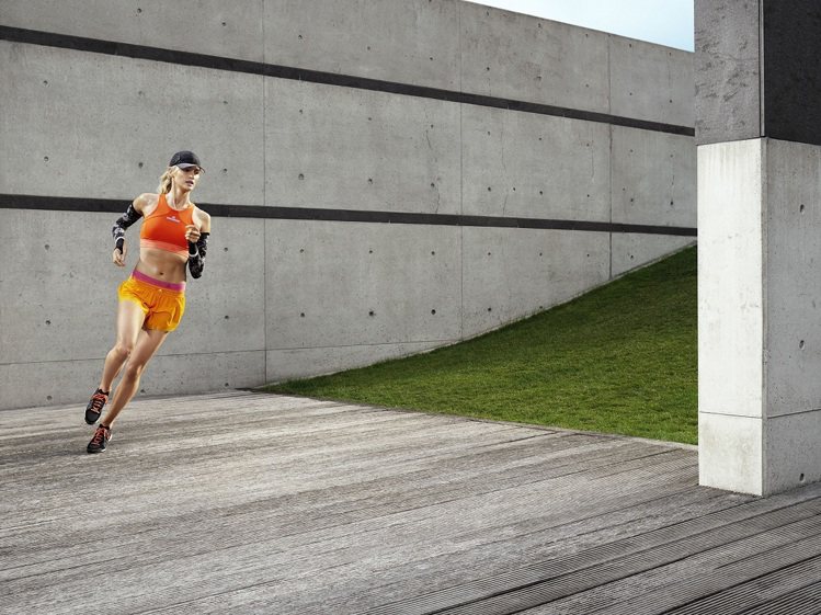 adidas與Stella McCartney的跑步裝備，以高彩度的亮橘ClimaChill 短版上衣搭配黃金色Adizero 跑步短褲。圖／adidas提供