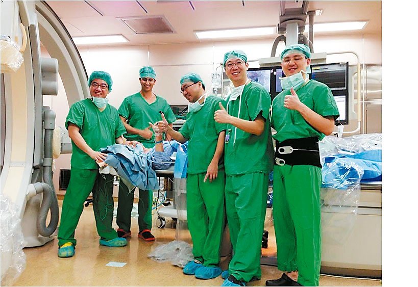 101歲人瑞盧先生在手術台接受「經導管人工主動脈瓣膜植入術」，過程清醒，還可跟開刀醫師握手、比讚。<br />圖／台大醫院提供
