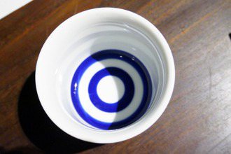 清酒酒器的基本款「蛇目杯」，兩個藍圈是為了觀察清酒的色澤而設計。 圖／朱慧芳