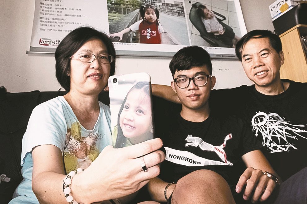 秦壽高將過世的女兒逸芳照片做成手機殼，找來全家一起合照。<br />圖／秦壽高提供