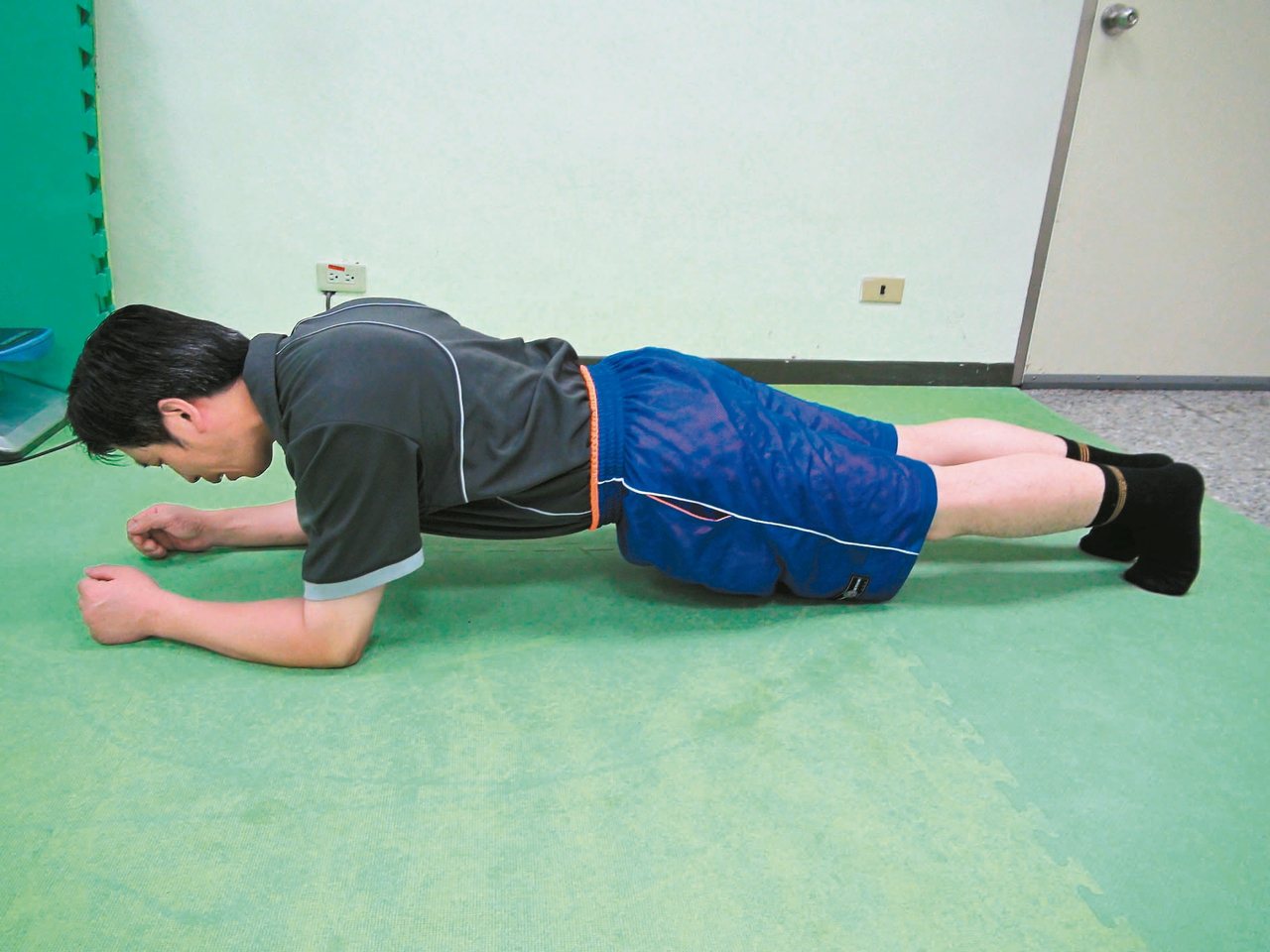 台大雲林分院物理治療組長李敬恩示範棒式運動，強調不標準的高強度運動，反而易受傷。