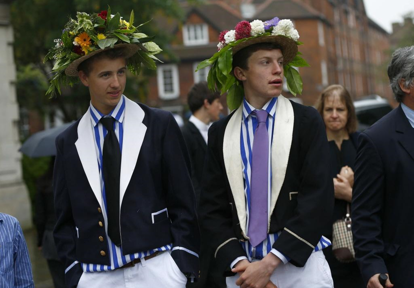 伊頓公學有著各式各樣悠久而奇特的傳統，如圖中白褲、條紋襯衫、綴滿花朵帽子的打扮，...