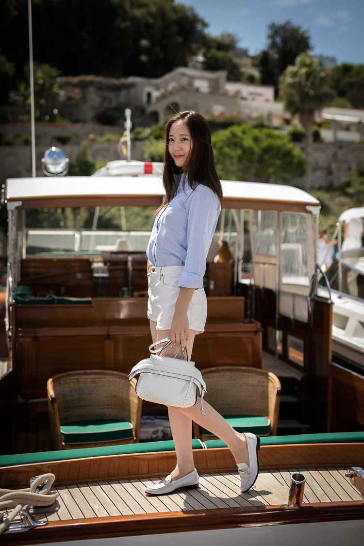 韓團f(x)的Krystal Jung手提白色TOD’S Wave Bag，搭配TOD’S Double T白色鞋款打造出遊裝扮。圖／TODS提供