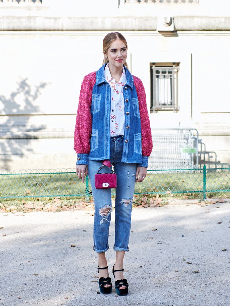Chiara Ferragni以今年秋冬很流行的包包裝飾法出現在CHANEL秀場外，搭配品牌秋冬系列粉紅軟呢拼接丹寧外套，顯得活潑有型。圖／巫昀穎提供
