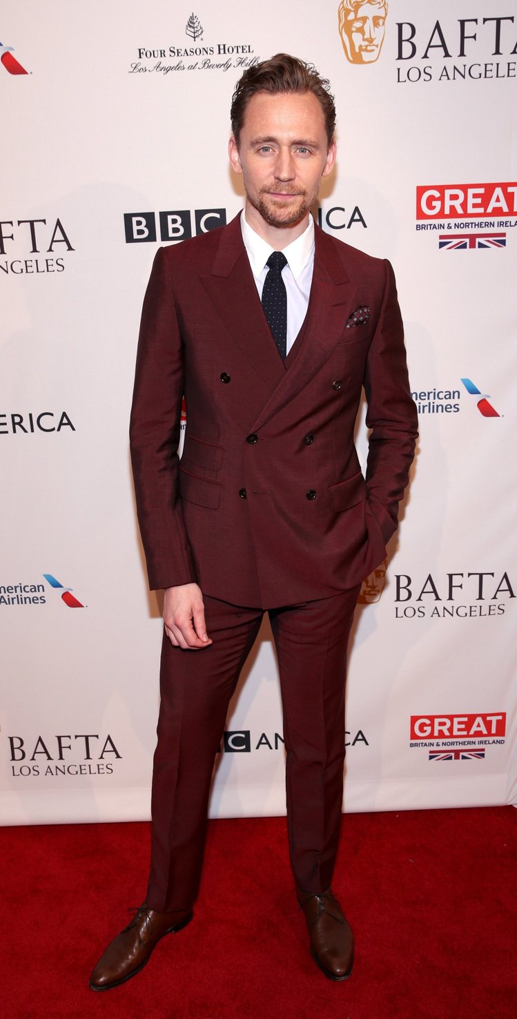 英國男星湯姆希德斯頓在英國電影和電視藝術學院（BAFTA）活動中身穿GUCCI 2017早春酒紅色雙排釦西裝。圖／GUCCI提供
