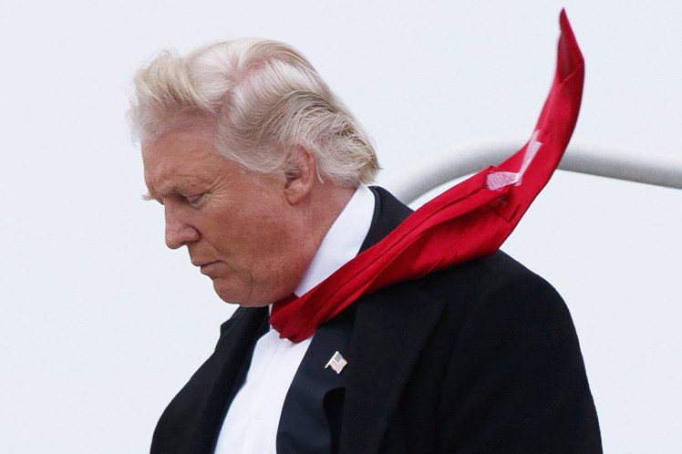 美國總統川普的領帶長到得靠膠帶固定，可見已到無法控制的地步。圖／美聯社