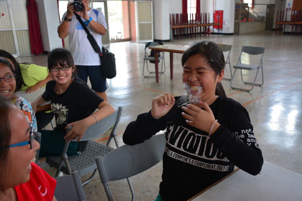 台南市山上國中老師今天到山上國小舉辦「液態氮」課程，　小朋友含著泡過液態氮的「乖...