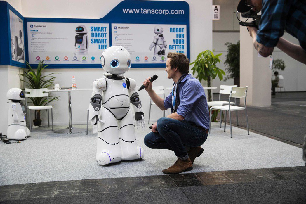 一個機器人在德國漢諾威科技展上接受電視媒體「採訪」。(歐新社)