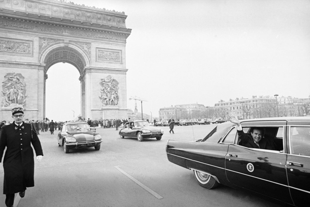 尼克森總統1969年2月28日訪問巴黎，他的座車離開凱旋門後，他把手伸到車窗外微...