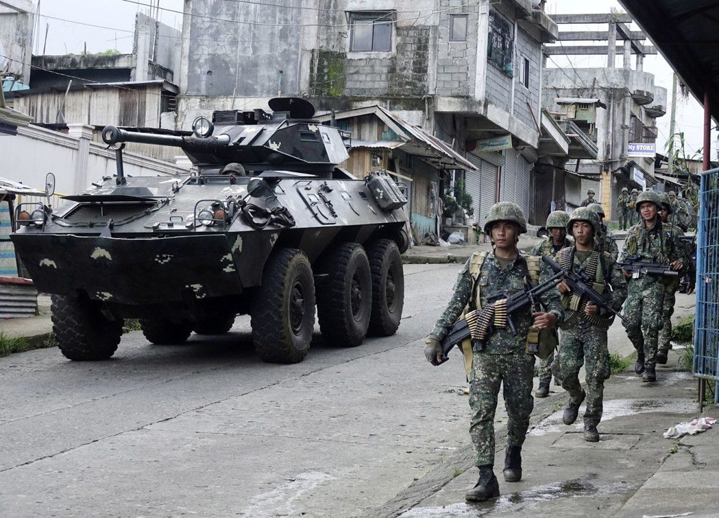 菲國政府軍隨裝甲車在馬拉韋市推進。圖／歐新社