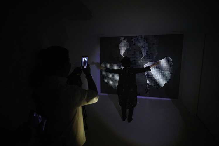 香奈兒J12多媒體體驗活動的一部分，當來賓站在黑牆前，便能感測參觀者的動作，隨之產生出層疊交錯的白色圖案，呼應「光影」概念。圖／CHANEL提供