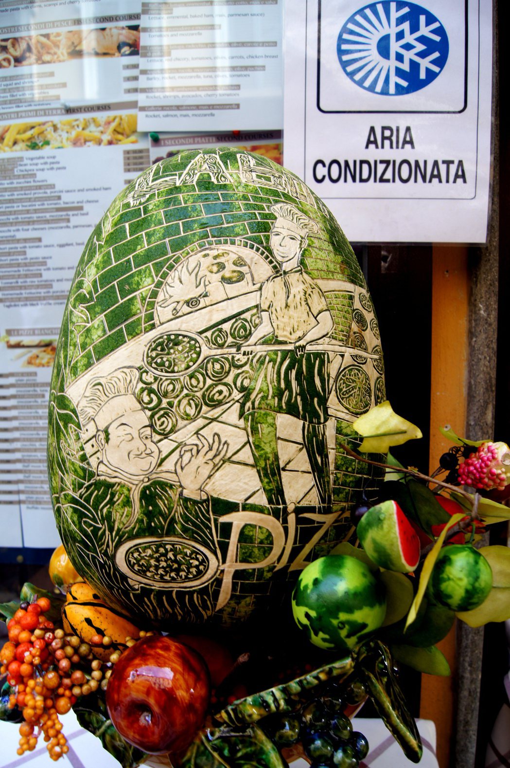 羅馬一家餐廳門前，廚師施展刀藝，在大西瓜的綠色外皮上，雕出窯烤披薩的畫面。 記者...