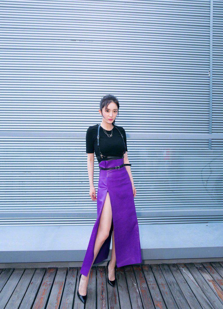 楊冪穿黑色上衣搭配Ferragamo紫色皮裙，開高衩的設計大秀美腿，腳踩Saint Laurent高跟鞋拉長整體線條。圖／Ferragamo提供