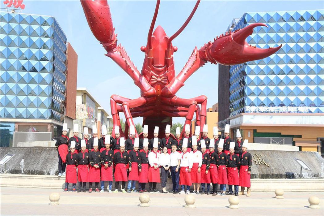 潛江龍蝦學院師生在龍蝦雕塑前合影。 圖/取材自微信
