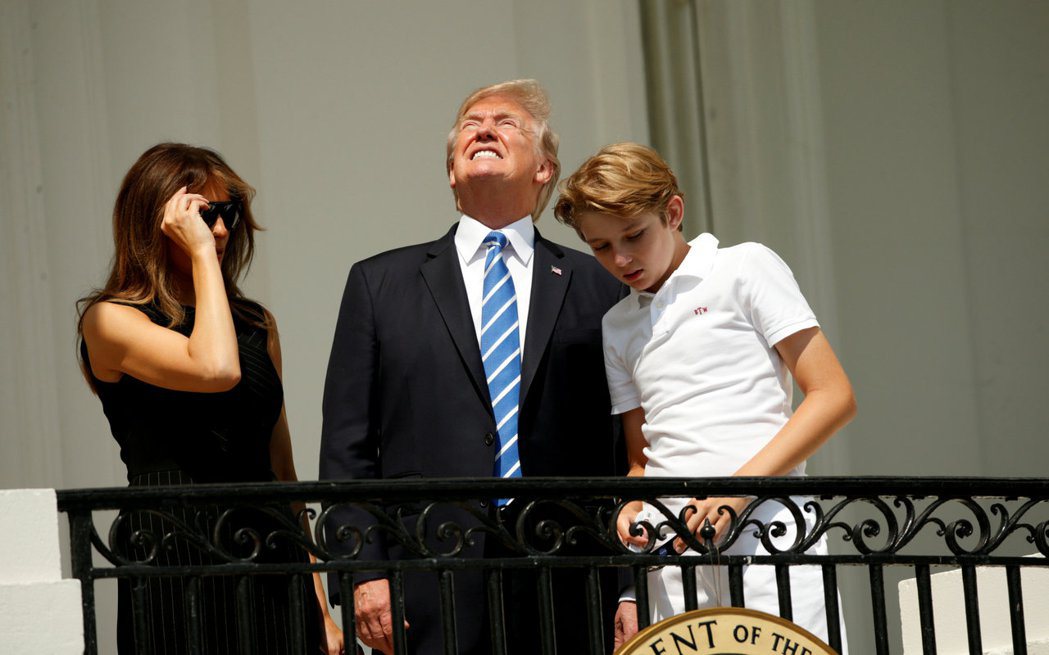 川普夫婦帶著么子拜倫（右）21日在白宮看日食。 路透