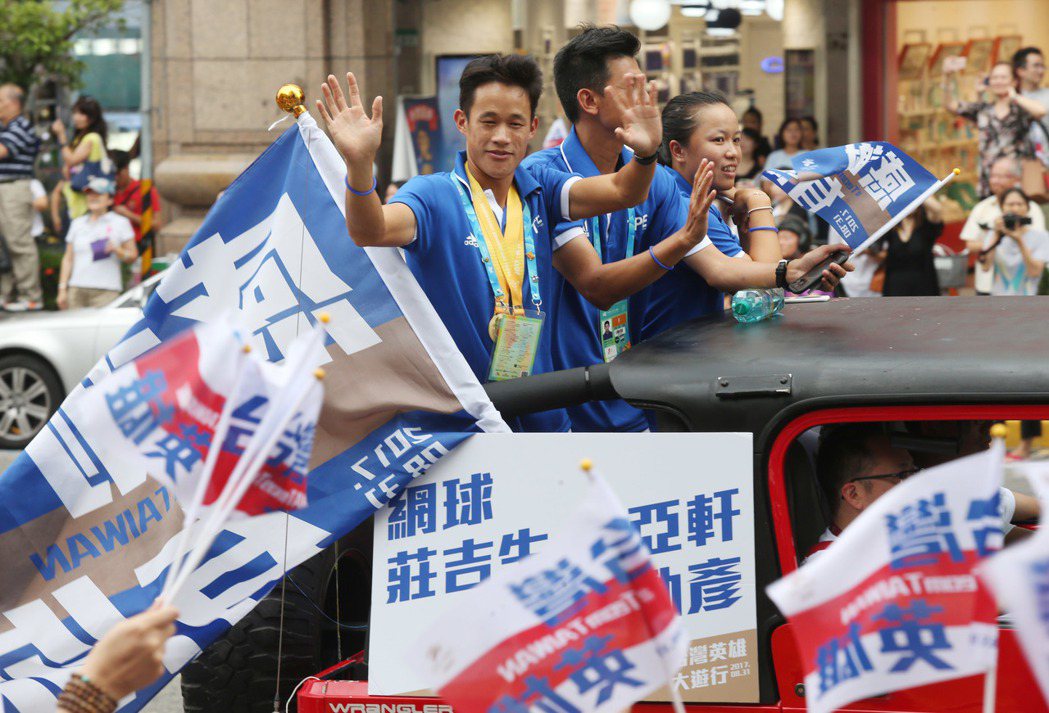 網球選手莊吉生、李亞軒(右)與教練在吉普車上，沿途受到民眾熱烈歡呼。 聯合報記者林俊良／攝影