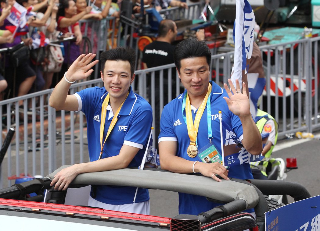 世大運勇奪羽球男單金牌的中華隊好手王子維（左）、教練張政雄（右）接受現場民眾熱情歡呼。 中央社