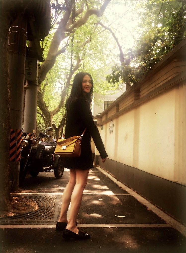 姚晨以黑色連衣裙搭含羞草黃Mademoiselle Longchamp包，簡約出色。圖／Longchamp提供