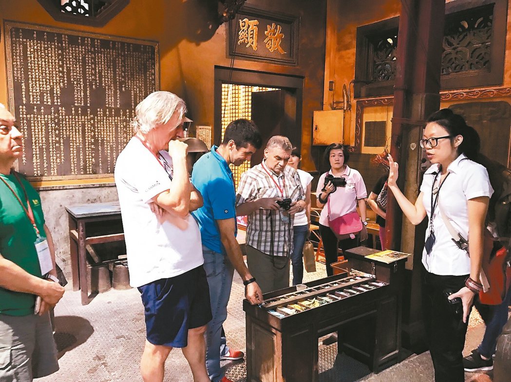 台南英語導覽員向外籍遊客解說寺廟拜拜流程。 圖／台南市第二官方語言專案辦公室提供