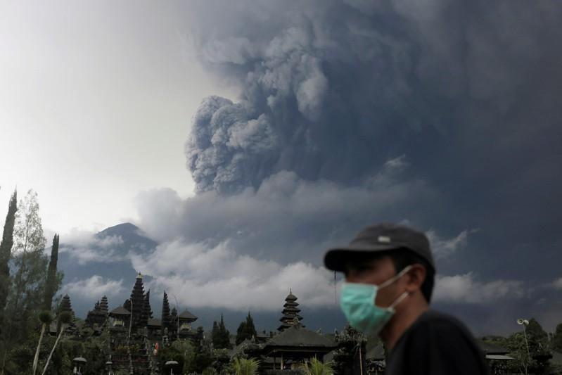 峇里島阿貢火山蠢蠢欲動，當地民眾戴口罩防吸入火山灰。 路透