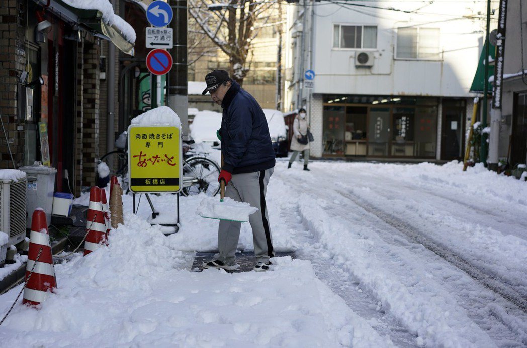 東京罕見大雪後，商家清除路邊積雪。 歐新社