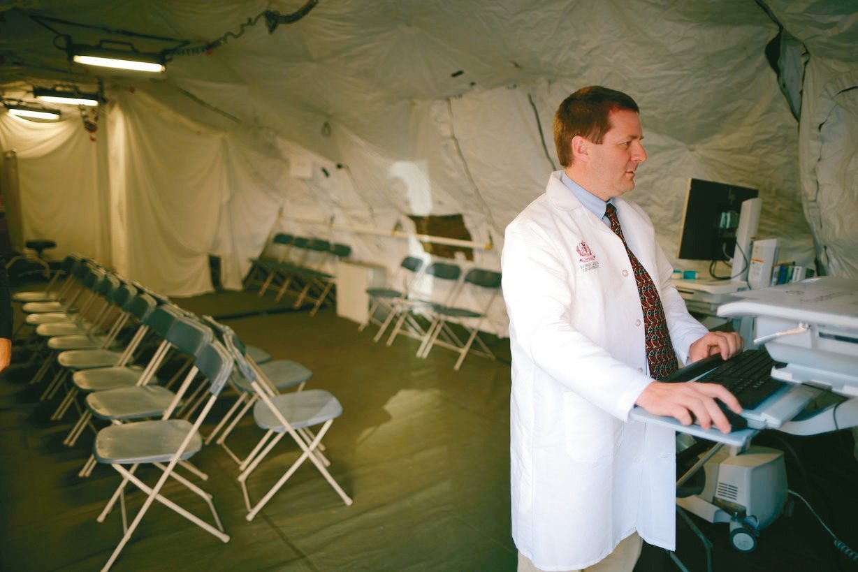 一名醫師在檢傷分類醫療帳篷裡處理公務。