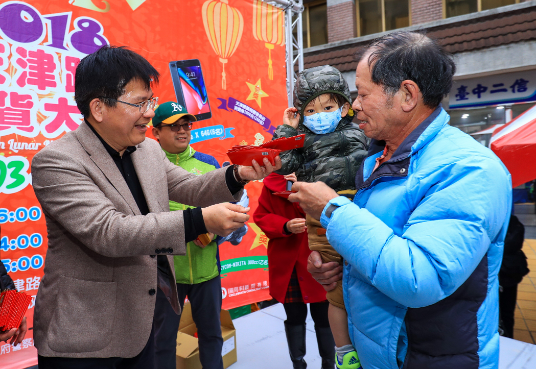台中市長林佳龍在天津年貨大街，發放狗年小紅包。 圖／台中市新聞局提供