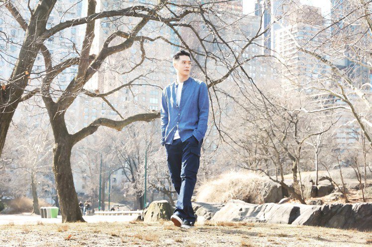 周湯豪身穿煙霧藍條紋亞麻襯衫搭配深藍色工作褲，在中央公園取景。圖／MICHAEL KORS提供