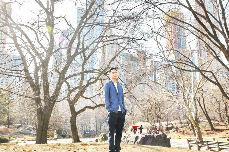 周湯豪身穿煙霧藍條紋亞麻襯衫搭配深藍色工作褲，在中央公園取景。圖／MICHAEL...