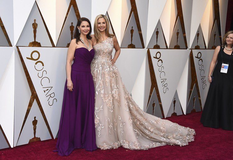 揭發好萊塢性騷擾惡習的女星米拉索維諾（右）和艾希莉賈德（右）一起走紅毯，艾希莉穿著Badgley Mishka訂製服搭配寶格麗珠寶，米拉索維諾穿Romana Kevaza設計師禮服。圖／美聯社