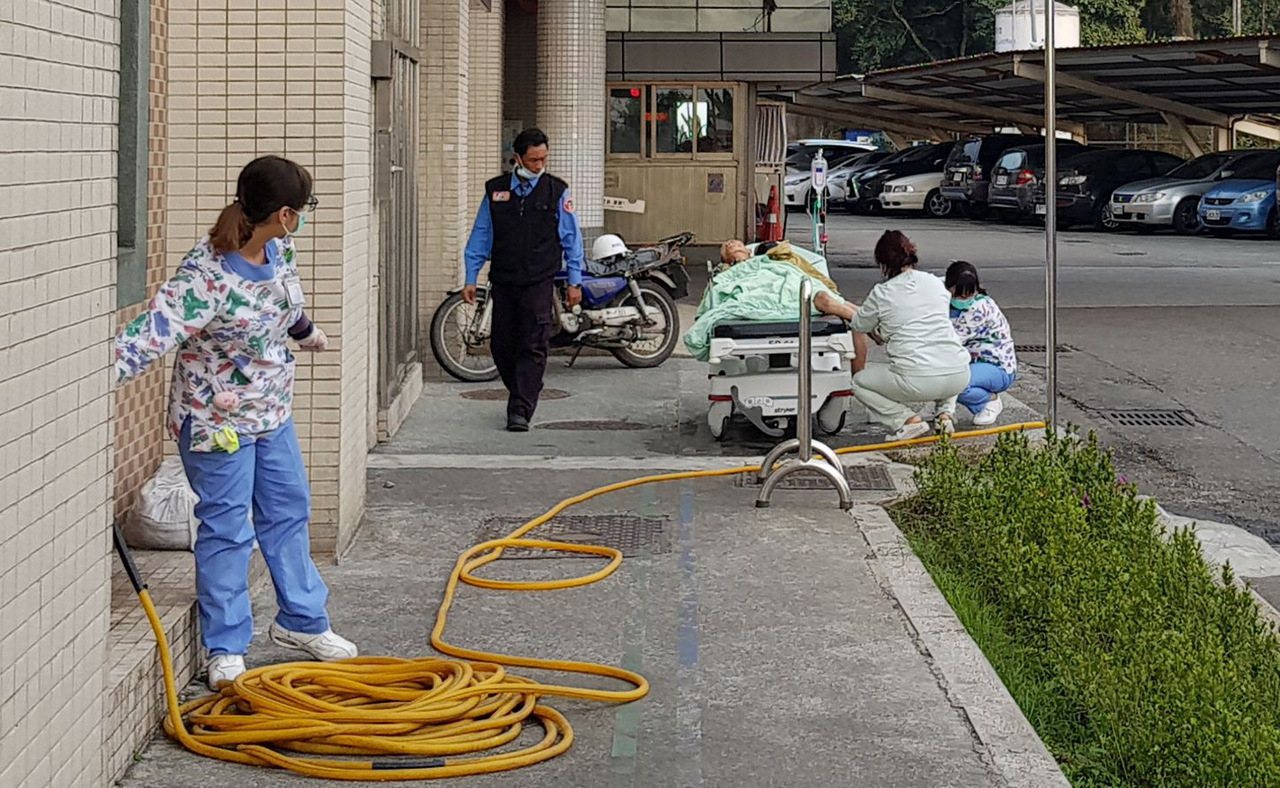 3名護士在醫院急診室外，替送醫的老人洗腳。圖／取自謝輝龍臉書
