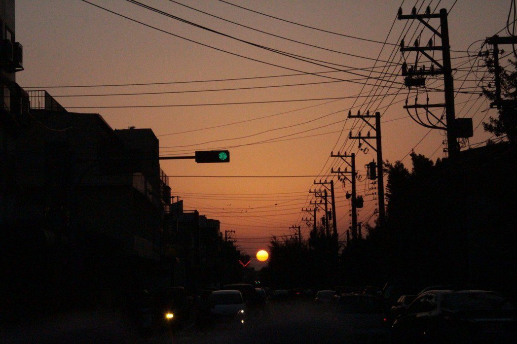 新竹市延平路一段、二段往南寮方向時，這幾天在筆直的一段道路盡頭，有一顆橘澄澄的夕陽，剛好在路中間，引起新竹民眾瘋傳。記者張雅婷／攝影
