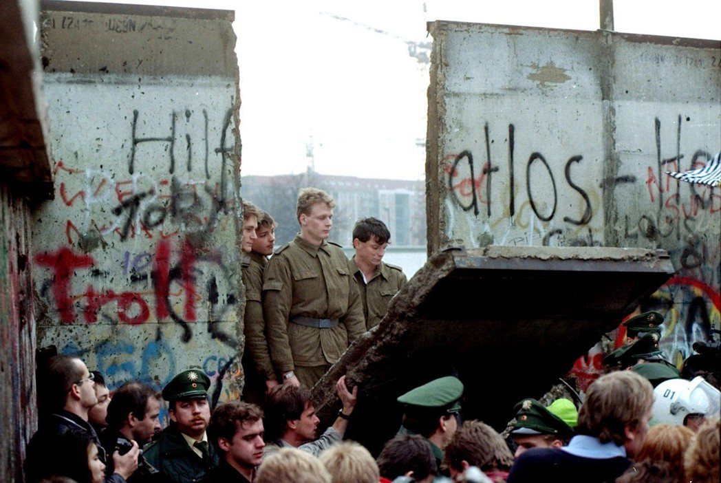 東西德在1990年統一，圖為東柏林邊境警察看著遭拉倒部分柏林圍牆的情形。 美聯社